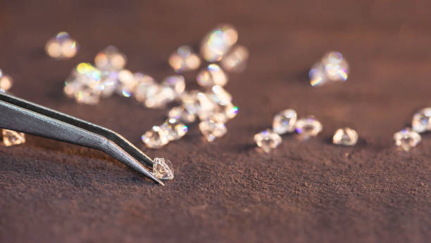 Diamond with tweezers and magnifier.reflections on the ground. brilliant cut diamond held by tweezers.Gemstone Beauty Diamond with tweezers and magnifier.reflections on the ground. brilliant cut diamond held by tweezers.Gemstone Beauty facet joint photos stock pictures, royalty-free photos & images