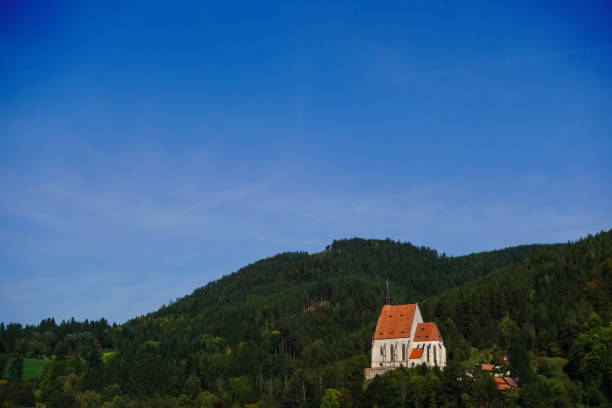 single church on a hill with a forest and blue sky