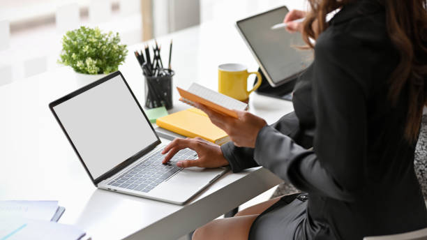 istock Elegant secretary working on laptop computer at the desk. 1352583684