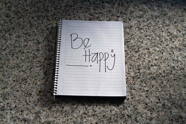 White striped notebook, on a granite background. Phrase \
