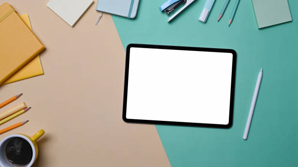 istock Digital tablet with empty display, stylus pen and stationery on colorful background. 1352584849