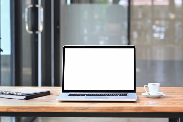 istock Computer laptop, coffee cup and books on wooden table. 1352585518