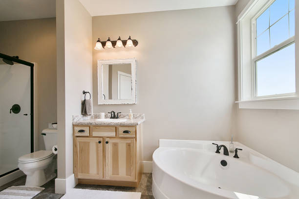istock Oval bathtub and natural wood vanity in master suite 1352586688
