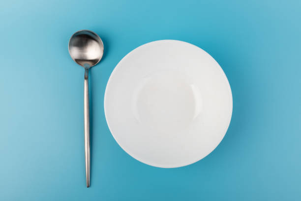 istock Empty plate with spoon on blue background. Flat lay Dishes for breakfast, lunch or dinner Mock up 1352591867