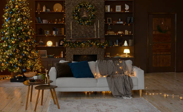 interior moderno de una sala de estar navideña con un hermoso sofá decorado con un árbol de navidad, chimenea y una gran estantería. decoraciones navideñas. - home decorating living room luxury fireplace fotografías e imágenes de stock