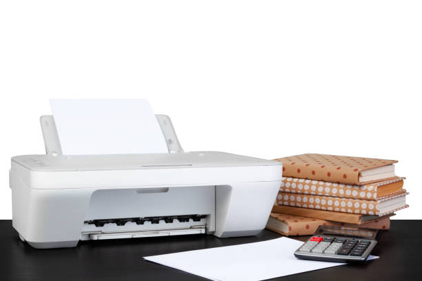 istock Printer and stack of books on black table against white background 1352594802