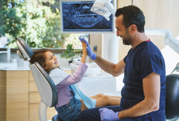 portret z bliska dentysty przyjmającego piątkę małej dziewczynce w klinice dentystycznej - dentist child cavity human teeth zdjęcia i obrazy z banku zdjęć