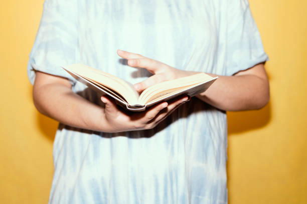 istock Woman in a tie dye shirt reading a book. 1352599091