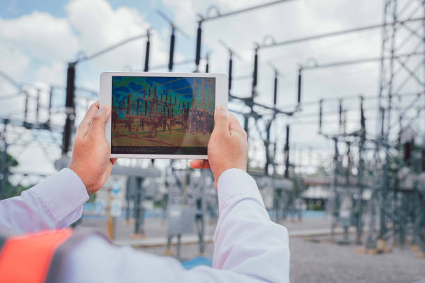 An electrical engineer uses a thermal meter to scan the structure and equipment of the power supply station to detect hot spots that can damage the system. Preventive maintenance stock photo