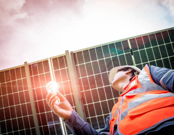 istock Technician holding the light bulb and the sun shines into the bulb and the solar panel. Alternative energy to conserve the world's energy, Photovoltaic module idea for clean energy production 1352600319