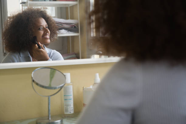 istock Woman looking at herself in the mirror while putting on makeup at home. 1352601188