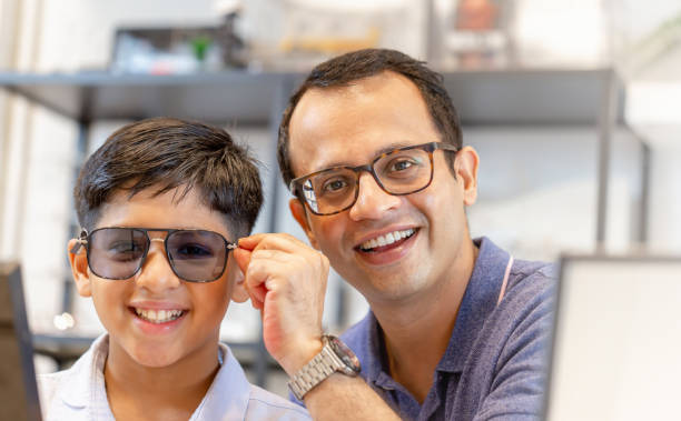 istock Indian father and son choosing eyeglasses in optics store 1352601218