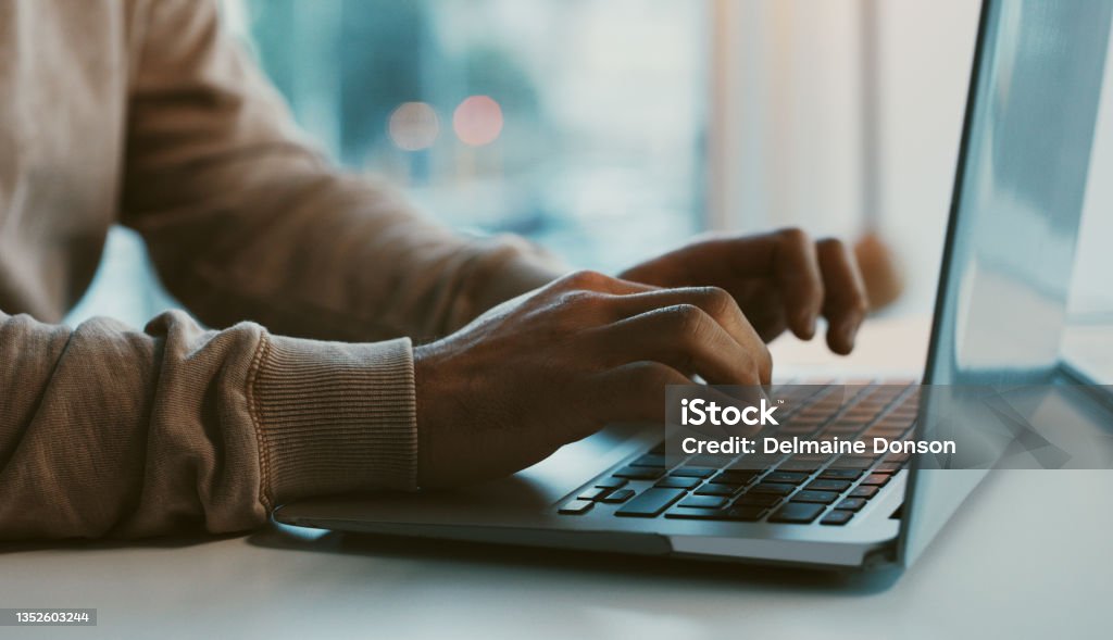 Shot of an unrecognizable businessman working on his laptop in the office Fate loves determination Computer Stock Photo