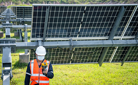 The technician takes the Thermoscan(thermal image camera) scan to the solar panel to check the hot spots in the cell, Concept to use technology to check the damage in the Solar plant.