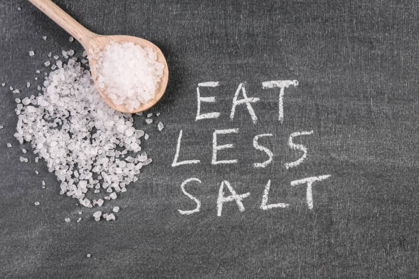 istock Wooden spoon on a chalk board. Eat Less Salt 1352609374
