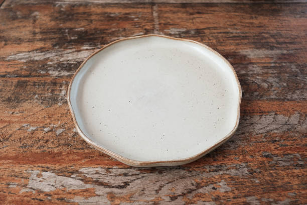 istock Empty ceramic shape plate for food on wooden table rustic background 1352609492