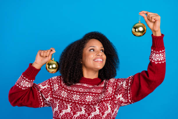 istock Photo of adorable dreamy lady wear print pullover holding baubles looking empty space smiling isolated blue color background 1352609632