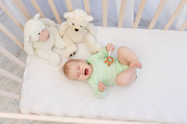 istock a crying baby in a crib with a teether in the bedroom 1352609713