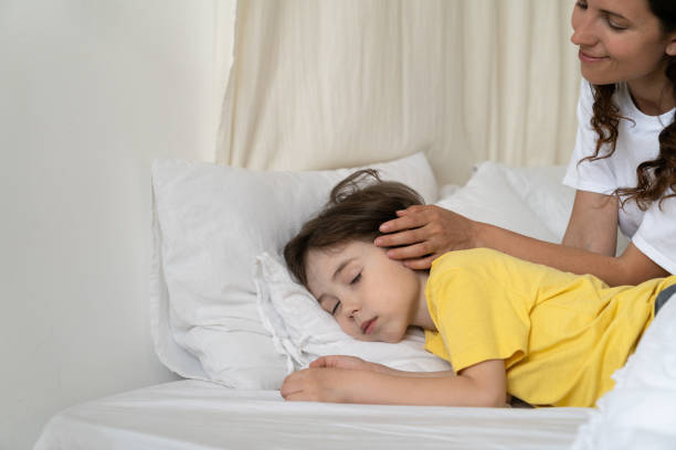 istock Mother Looking At Sleeping Daughter On Bed At Home 1352610688