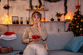 Woman watching movie and eating snacks at Christmas