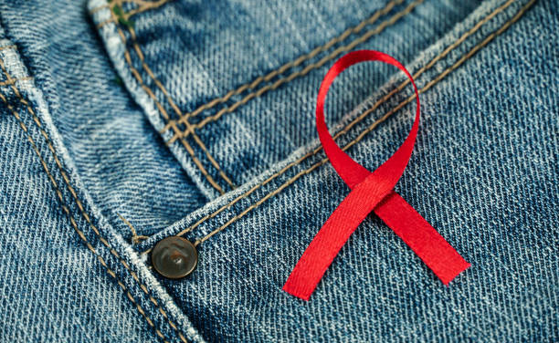 jeans avec ruban rouge, journée mondiale de lutte contre le sida - sex condom jeans horizontal photos et images de collection