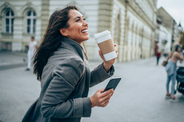 istock Young woman texting on the street. 1352616524