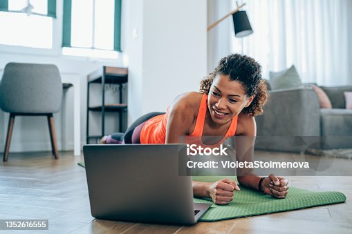 istock Sporty woman exercising at home. 1352616555