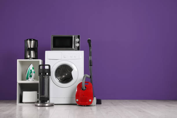 juego de diferentes electrodomésticos con aspiradora sobre fondo morado en interiores. espacio para texto - wash stand fotografías e imágenes de stock