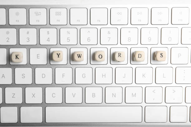 Overhead view of a composed  alphanumeric computer keyboard with five blank red keys on silver gradient to white with copy space above