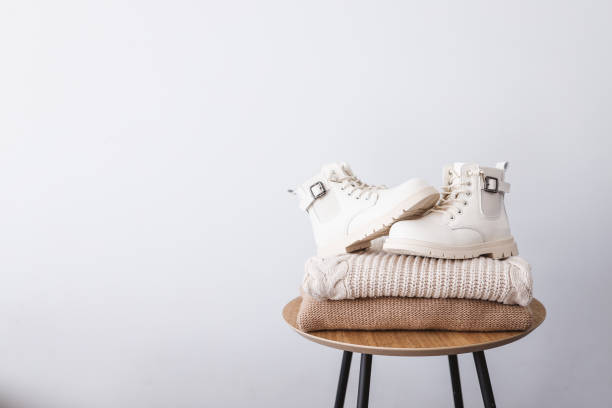 istock Stack of sweaters and boots on a wooden table. Place for text. Advertising 1352617993