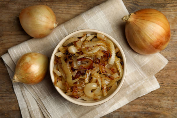 istock Tasty fried onion on wooden table, flat lay 1352619044