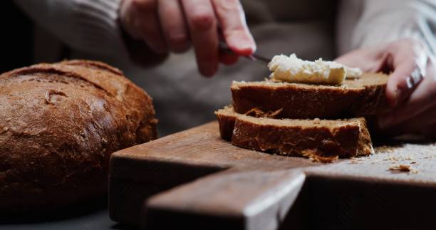 istock Human hands are spreading cream cheese on a slice of bread 1352619263