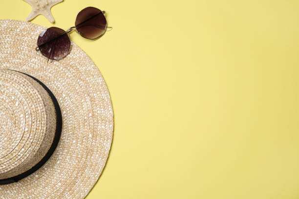 istock Hat, sunglasses and starfish on yellow background, flat lay with space for text. Beach objects 1352619442