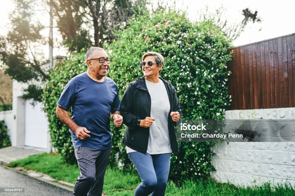 Shot of a senior couple bonding together while running outdoors Bonding and keeping fit Exercising Stock Photo