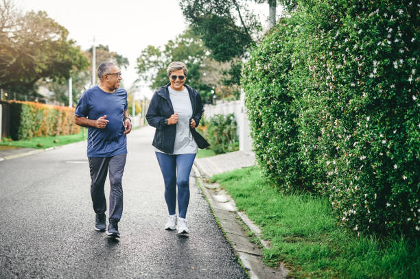 Full length shot of a senior couple bonding together while running outdoors We keep each other motivated active seniors stock pictures, royalty-free photos & images