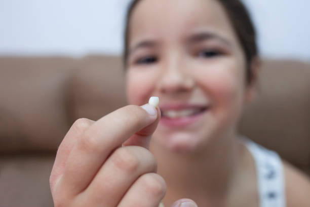istock 9 years old girl showing her first canine tooth fallen out 1352620737
