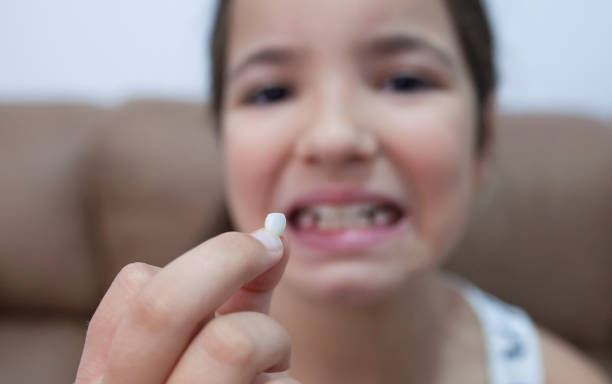 istock 9 years old girl showing her first canine tooth fallen out 1352620738