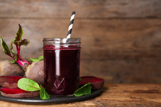 istock Freshly made beet juice on wooden table. Space for text 1352620831