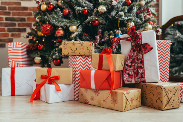 regalos multicolores bajo el primer plano de la foto del árbol de navidad víspera de año nuevo, regalos multicolores, rojo, gris y negro - debajo de fotografías e imágenes de stock
