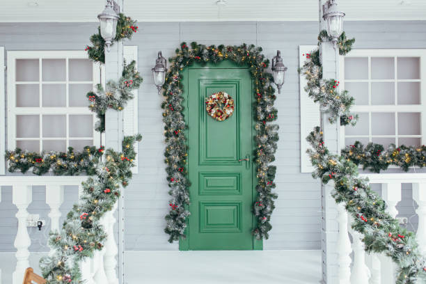 집에 녹색 문 입구. 크리스마스 나뭇가지로 장식 된 크리스마스 축제 데코 - wreath christmas door snow 뉴스 사진 이미지