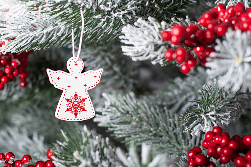 white Christmas angel on a tree. Wooden angel on the Christmas tree. Macro photo.