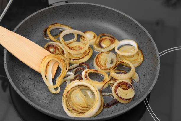 Cooking onion rings in frying pan, closeup