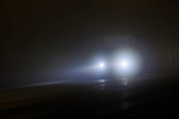 defocused alone minivan moving on empty night foggy road.