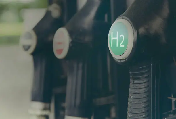 Photo of Hydrogen logo on gas stations fuel dispenser. Concept for emission free eco friendly transportation. Green energy. Fuel filler nozzle to fill hydrogen powered vehicles