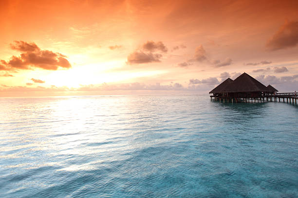 resort maldivian houses on sunrise
