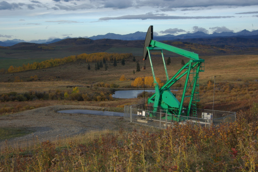 An oil pump is situated in one of the most beautiful areas of the Alberta Foothills. It is Autumn and the colours are superb.