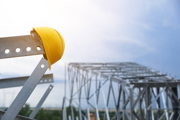 istock High voltage tower construction with yellow hard hat outdoors. Installation of electrical substation 1352642321