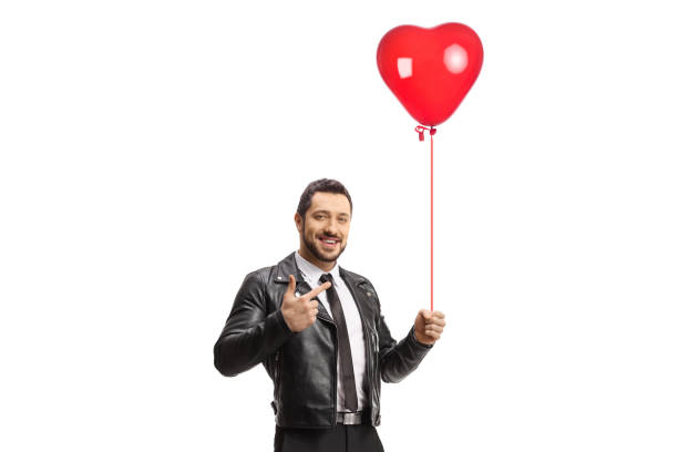 istock Guy holding a red heart balloon and pointing 1352642991