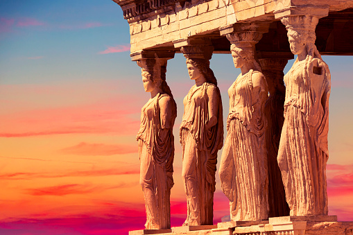 Detail of Caryatid Porch on the Acropolis uring colorful sunset in Athens, Greece. Ancient Erechtheion or Erechtheum temple. World famous landmark at the Acropolis Hill