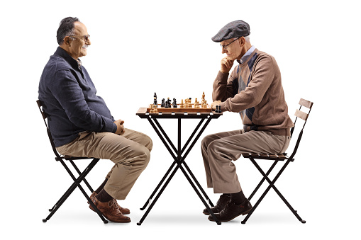 Two elderly men playing chess isolated on white background